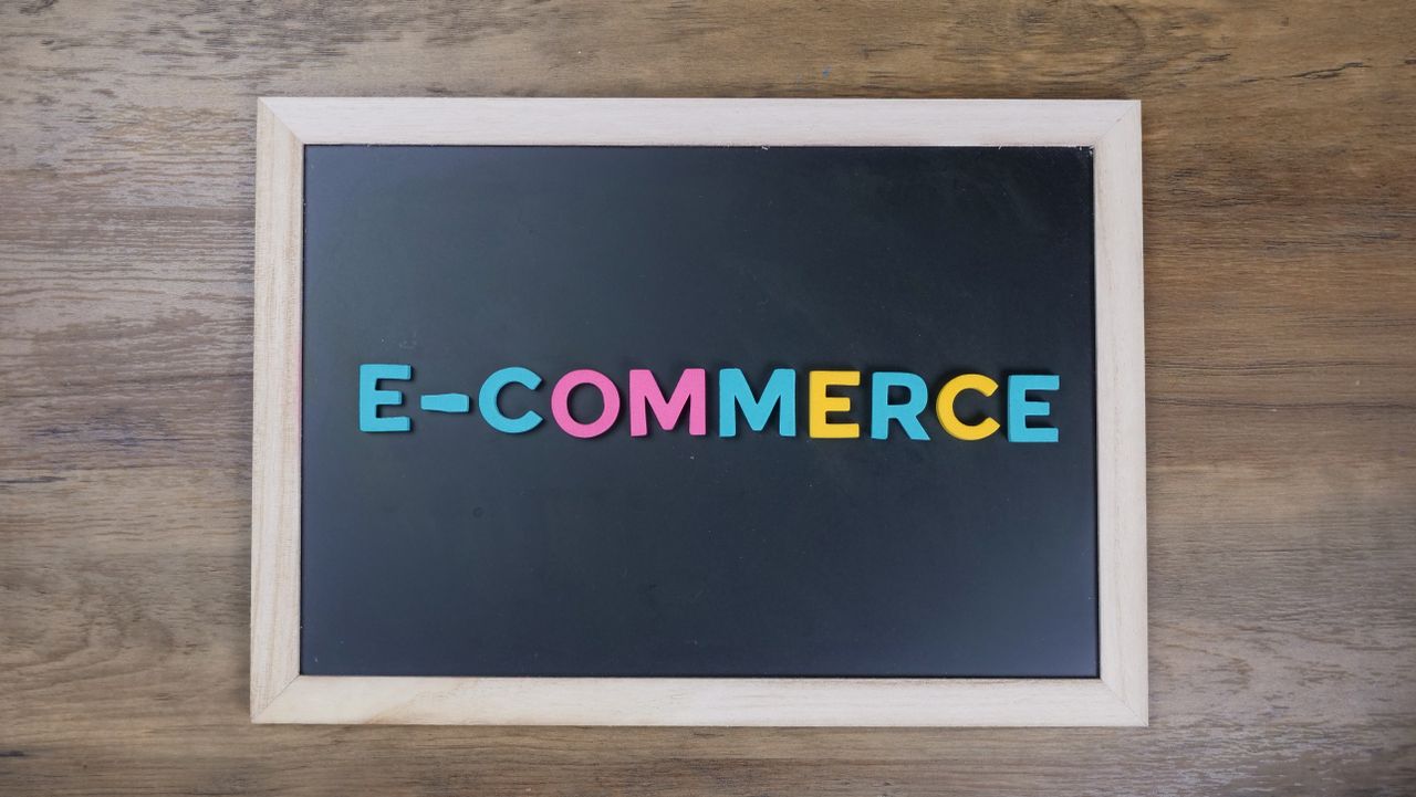 team-02 Colorful letters spelling e-commerce on a wooden framed blackboard.